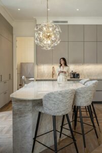 Woman enjoying modern kitchen with beautiful programmed lighting design by Hi-Concept.